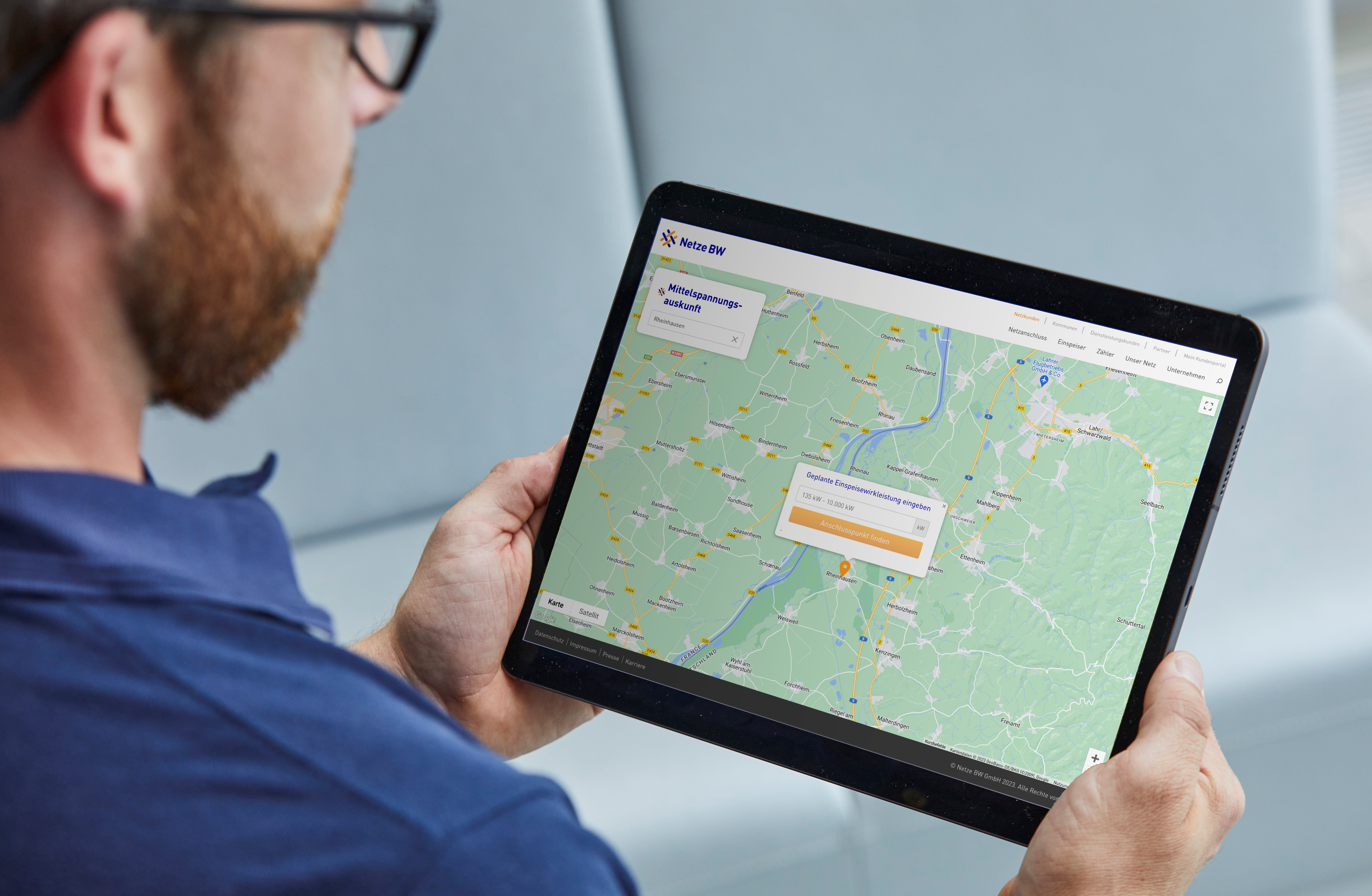 Mann betrachtet Karte auf Tablet. Mittelspannungs-Auskunft.